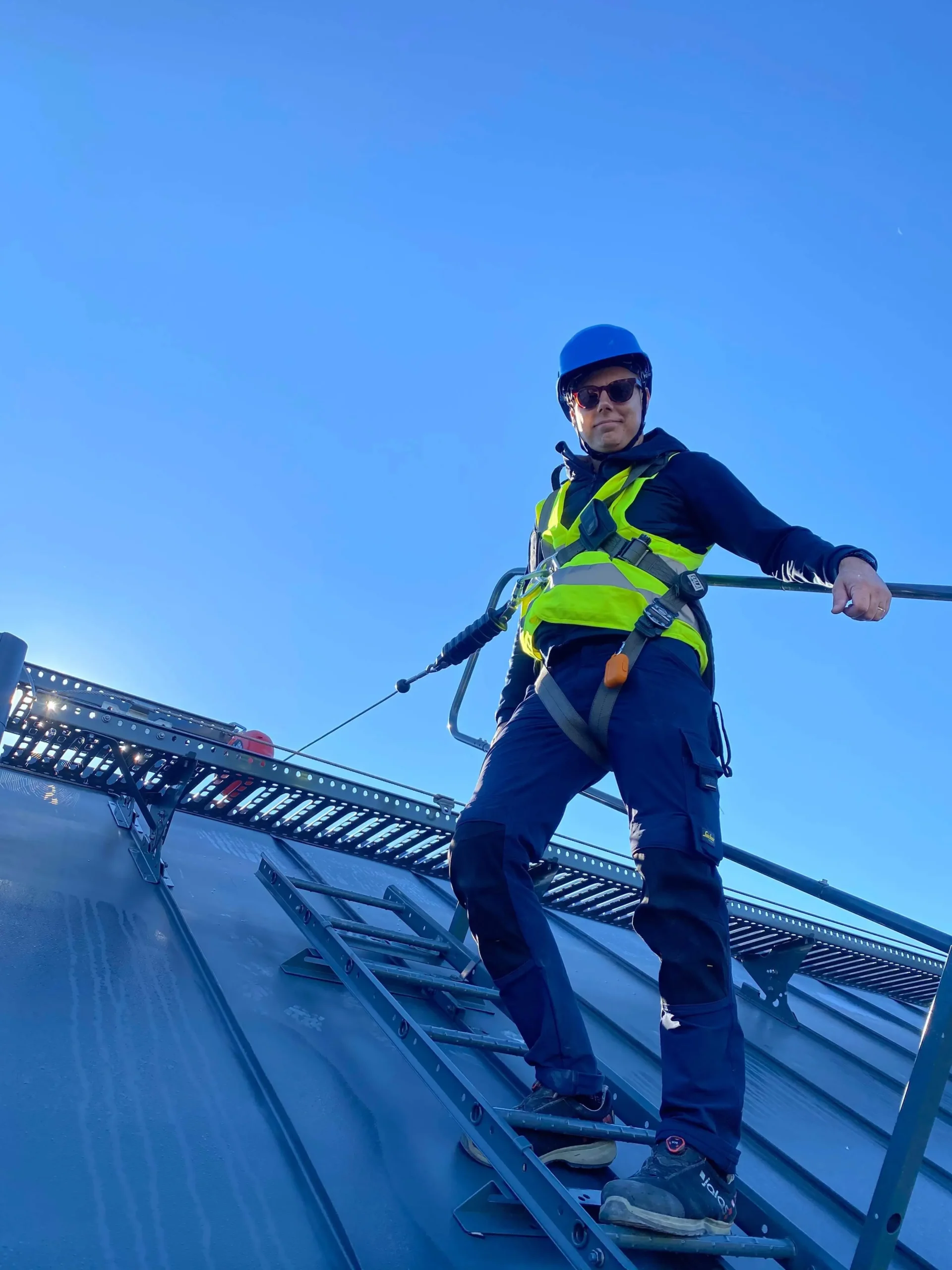 Person uppe på ett tak i samband med ventilationsmontage